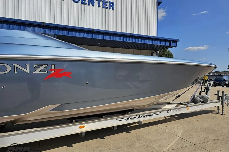 Slide: The Image of 2007 Donzi 35 ZR boat on trailer outside a marine center, clear sky background. - 5