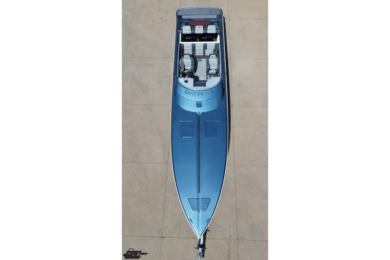 Slide: The Image of Aerial view of a 2007 Donzi 35 ZR speedboat in blue, docked on a concrete surface. - 78