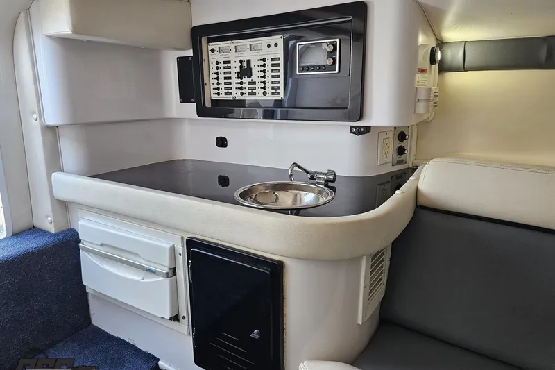 Slide: The Image of Interior of a 2007 Donzi 35 ZR boat featuring a compact kitchenette and control panel. - 94