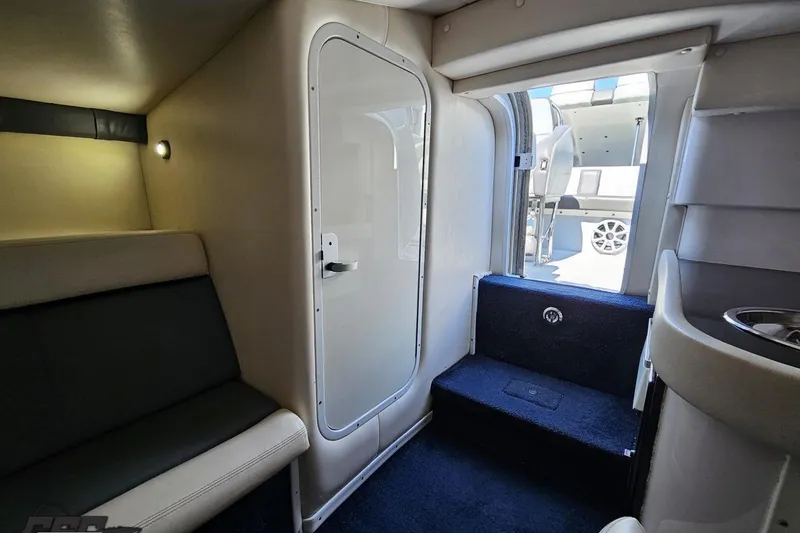 Slide: The Image of Interior cabin of a 2007 Donzi 35 ZR boat, featuring seating and a door. - 99