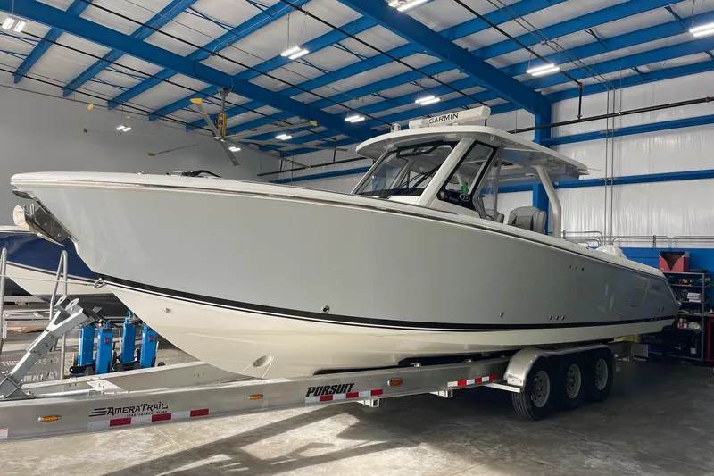 The Image of 2022 Pursuit S 328 Sport boat on trailer in indoor storage facility. - 1