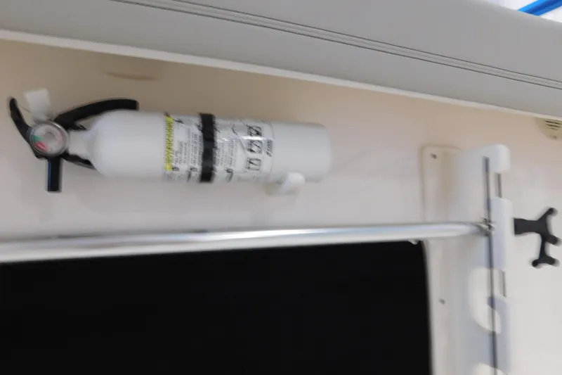 Slide: The Image of Fire extinguisher mounted on 2022 Pursuit S 328 Sport boat interior. - 12