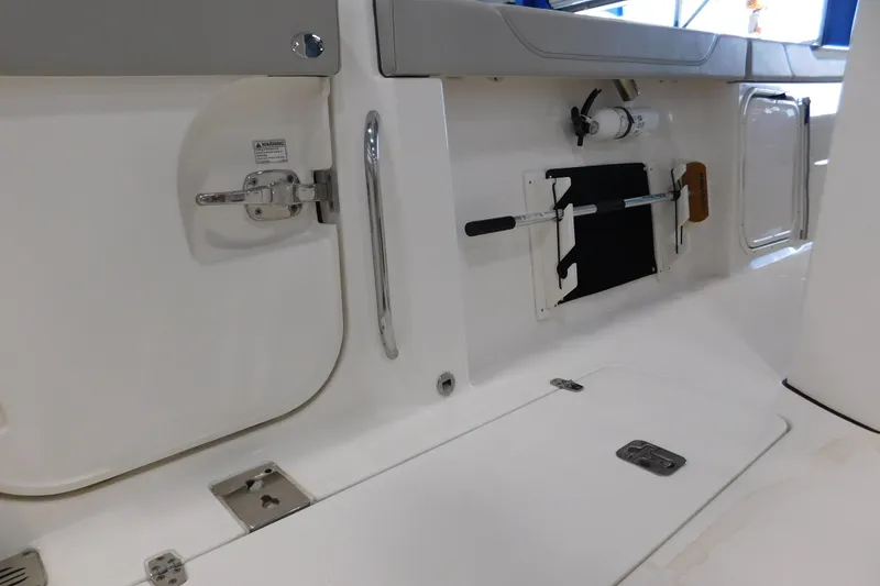 Slide: The Image of 2022 Pursuit S 328 Sport boat interior with storage compartments and safety equipment. - 15