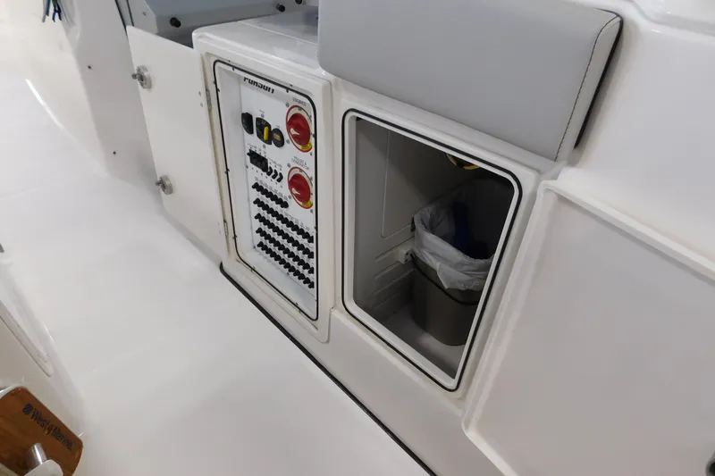 Slide: The Image of 2022 Pursuit S 328 Sport boat interior with control panel and storage compartment. - 22