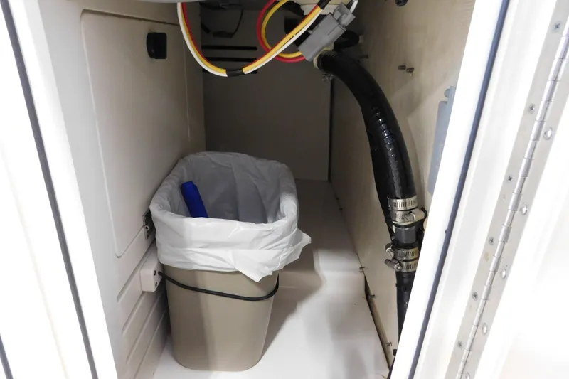 Slide: The Image of Interior storage compartment of 2022 Pursuit S 328 Sport boat with trash bin. - 23