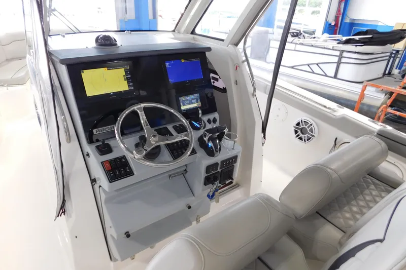 Slide: The Image of 2022 Pursuit S 328 Sport boat cockpit with advanced navigation system and steering wheel. - 25