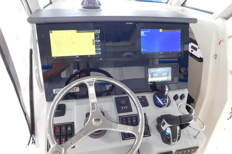 Slide: The Image of 2022 Pursuit S 328 Sport boat dashboard with Garmin displays and steering wheel. - 27