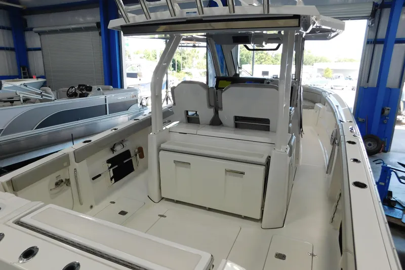 Slide: The Image of 2022 Pursuit S 328 Sport boat interior in a showroom, showcasing seating and storage. - 3