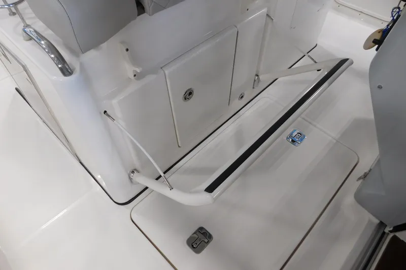 Slide: The Image of 2022 Pursuit S 328 Sport boat interior with sleek white seating and storage compartments. - 35