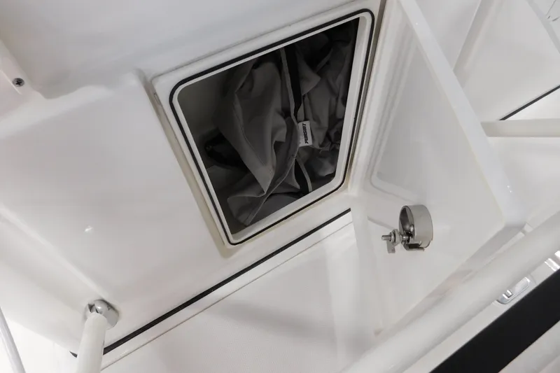 Slide: The Image of 2022 Pursuit S 328 Sport boat storage compartment with open hatch and visible interior bag. - 36