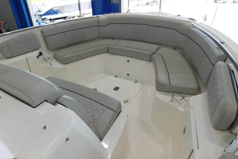Slide: The Image of 2022 Pursuit S 328 Sport boat interior with gray cushioned seating. - 38