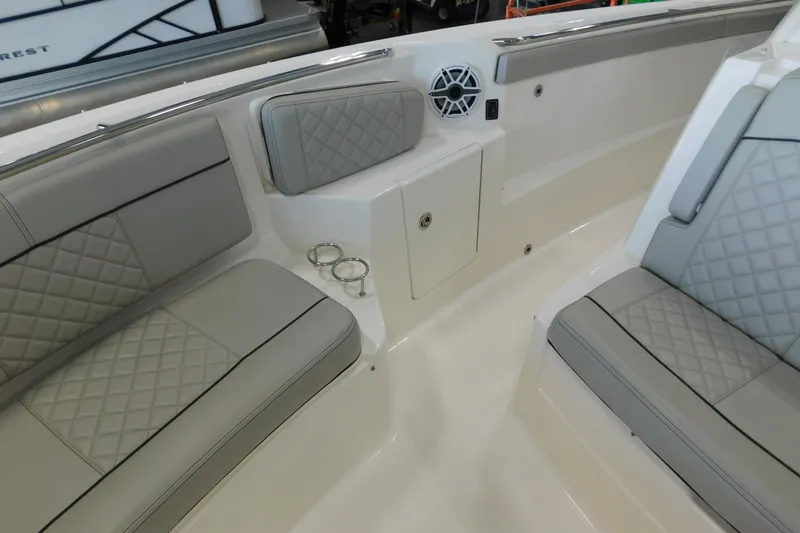 Slide: The Image of 2022 Pursuit S 328 Sport boat interior with cushioned seating and cup holders. - 40