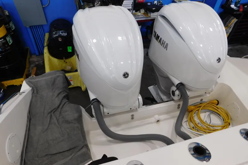 Slide: The Image of 2022 Pursuit S 328 Sport boat with twin Yamaha outboard engines in a workshop setting. - 5