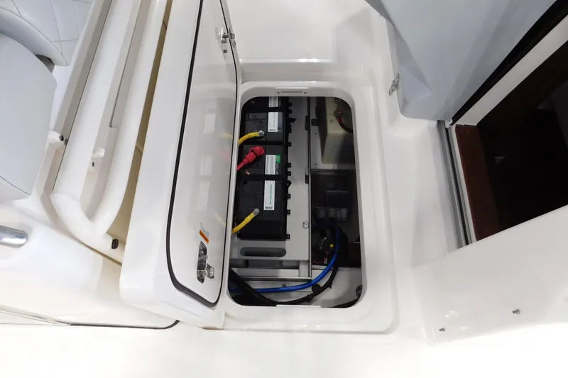 Slide: The Image of 2022 Pursuit S 328 Sport boat battery compartment with wiring and secure storage. - 59