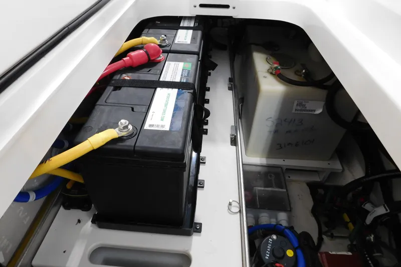 Slide: The Image of 2022 Pursuit S 328 Sport boat battery compartment with wiring and storage. - 60