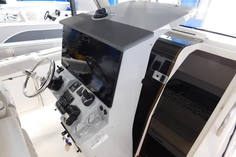 Slide: The Image of 2022 Pursuit S 328 Sport boat helm with steering wheel and control panel. - 63