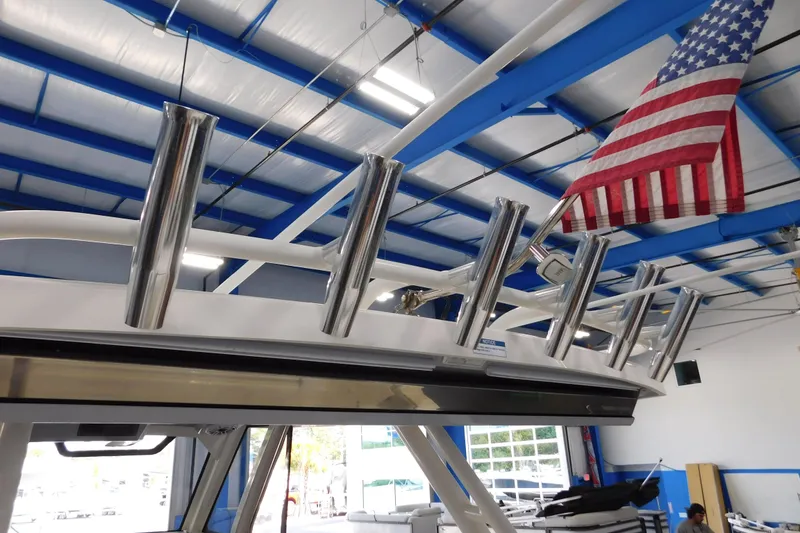 Slide: The Image of 2022 Pursuit S 328 Sport boat with rod holders and American flag in a showroom. - 67