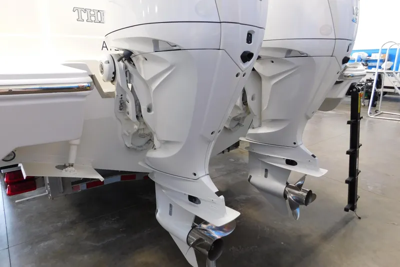 Slide: The Image of 2022 Pursuit S 328 Sport boat with dual outboard engines in a showroom. - 73