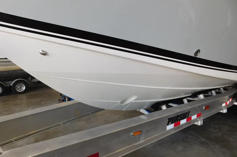 Slide: The Image of 2022 Pursuit S 328 Sport boat on trailer, showcasing sleek hull design. - 79
