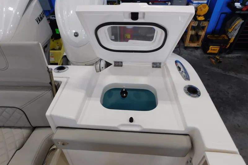 Slide: The Image of 2022 Pursuit S 328 Sport boat with open livewell and Yamaha engine in a workshop. - 8