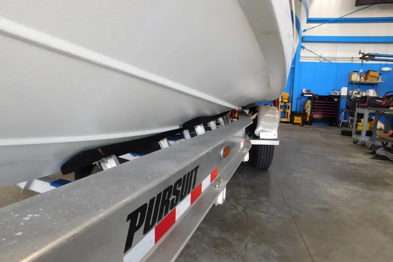 Slide: The Image of 2022 Pursuit S 328 Sport boat on trailer in a workshop setting. - 80