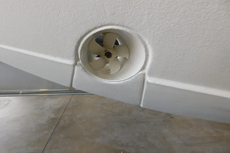 Slide: The Image of 2022 Pursuit S 328 Sport boat thruster detail in a garage setting. - 81