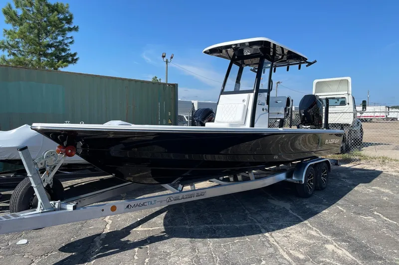 Slide: The Image of 2026 Blazer 2550 GTS boat on trailer, parked outdoors under clear blue sky. - 11