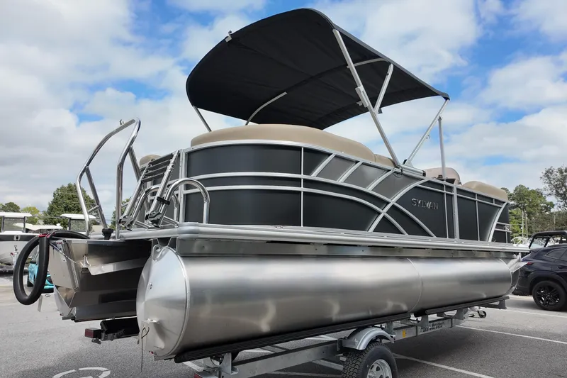 Slide: The Image of 2026 Sylvan Mirage 822 LZ pontoon boat on trailer, under a cloudy sky. - 13