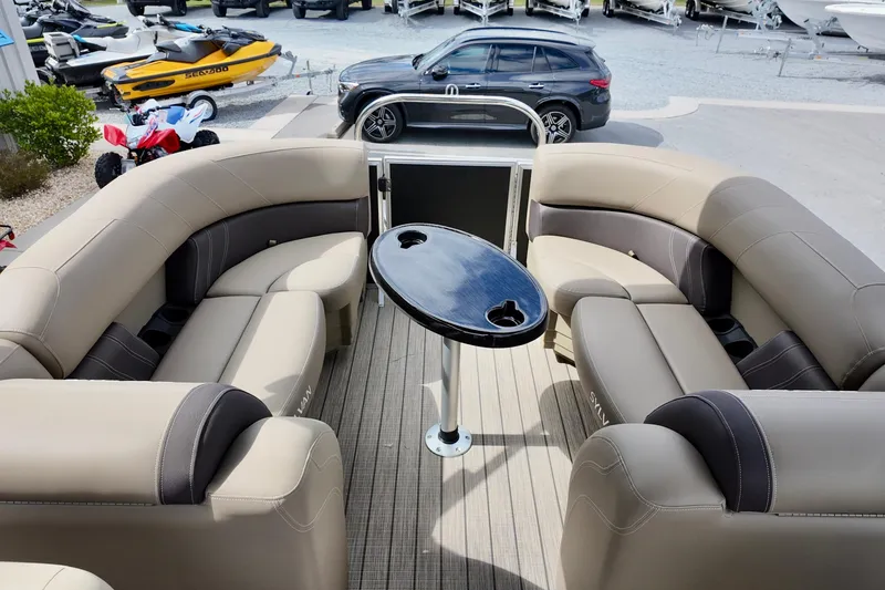 Slide: The Image of 2026 Sylvan Mirage 822 LZ pontoon boat interior with beige seating and central table. - 8
