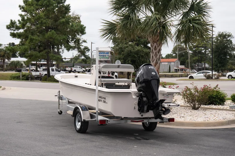 Slide: The Image of 2026 Carolina Skiff E18 JVX CC boat on trailer, parked outdoors. - 4