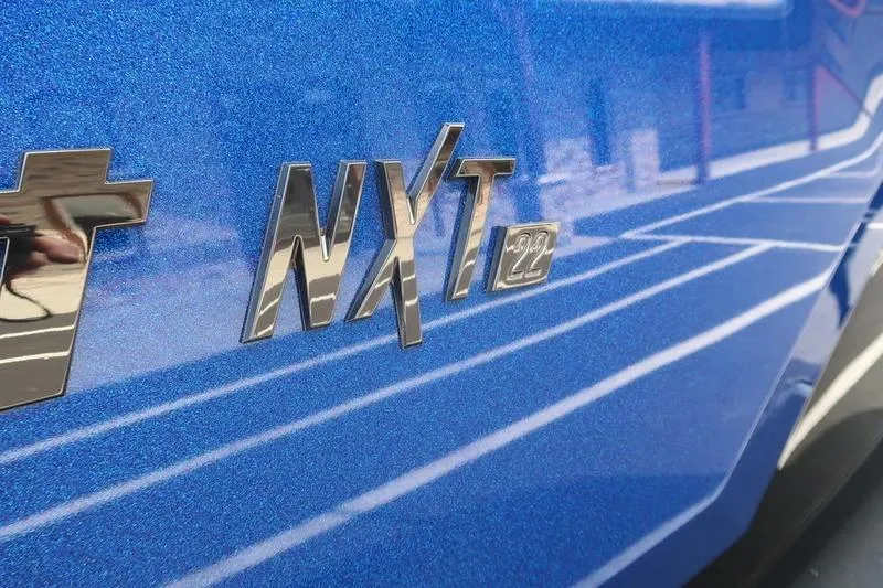 Slide: The Image of 2026 MasterCraft NXT22 boat rear view in parking lot. - 11