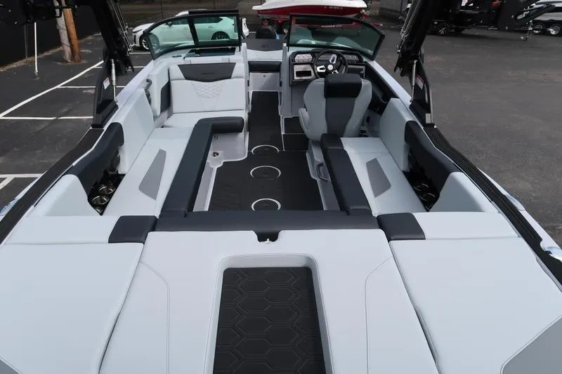 Slide: The Image of 2026 MasterCraft NXT22 boat on trailer in parking lot, blue and gray design. - 7