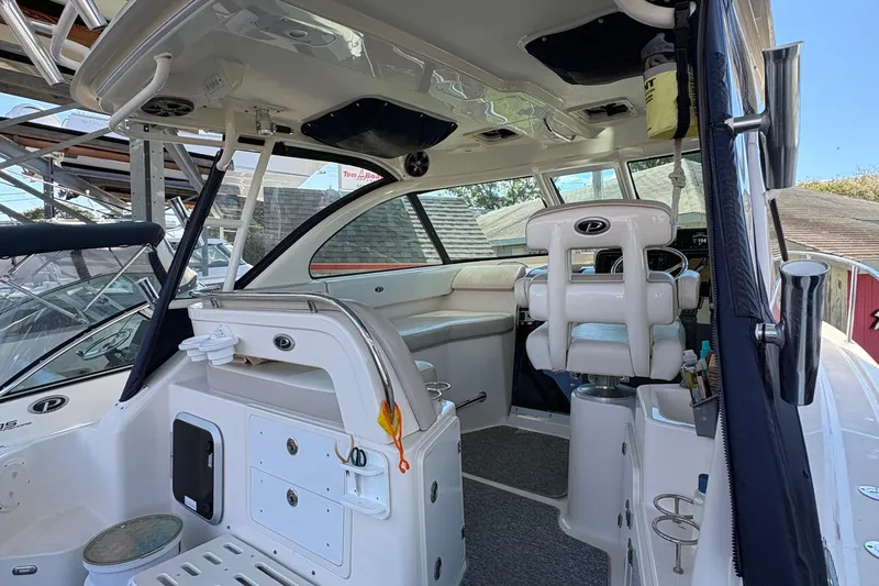 Slide: The Image of 2013 Pursuit OS 315 Offshore boat deck with open storage compartment and fishing gear. - 25