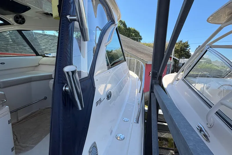Slide: The Image of 2013 Pursuit OS 315 Offshore boat docked, showcasing front deck and windshield. - 32