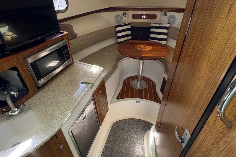 Slide: The Image of Open storage compartment on 2013 Pursuit OS 315 Offshore boat with various items inside. - 34