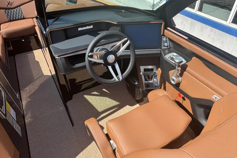 Slide: The Image of 2026 MasterCraft XT24 boat interior with modern steering and brown leather seating. - 10