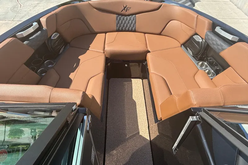 Slide: The Image of 2026 MasterCraft XT24 boat interior with brown leather seating and cup holders. - 11