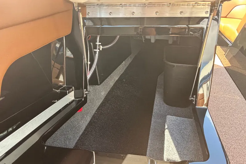 Slide: The Image of 2026 MasterCraft XT24 boat interior storage compartment with sleek design and carpeting. - 15