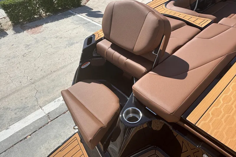 Slide: The Image of 2026 MasterCraft XT24 boat interior with brown seating and cup holder. - 4