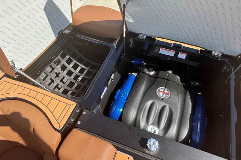 Slide: The Image of 2026 MasterCraft XT24 boat engine compartment with open storage and visible engine components. - 6