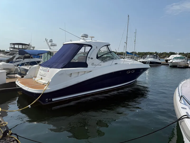 The Image of 2004 Sea Ray 390 Sundancer yacht docked at marina, featuring sleek design and blue canopy. - 0