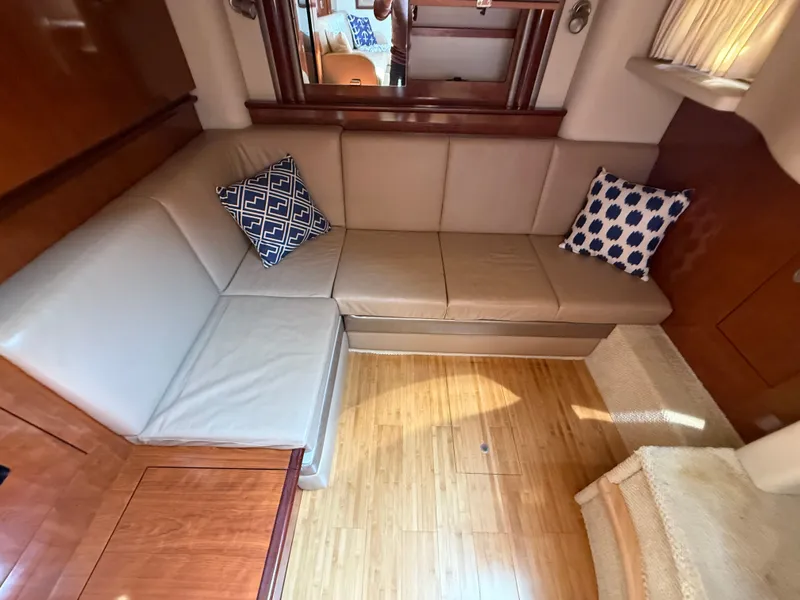 Slide: The Image of Interior of 2004 Sea Ray 390 Sundancer with beige leather seating and decorative pillows. - 10