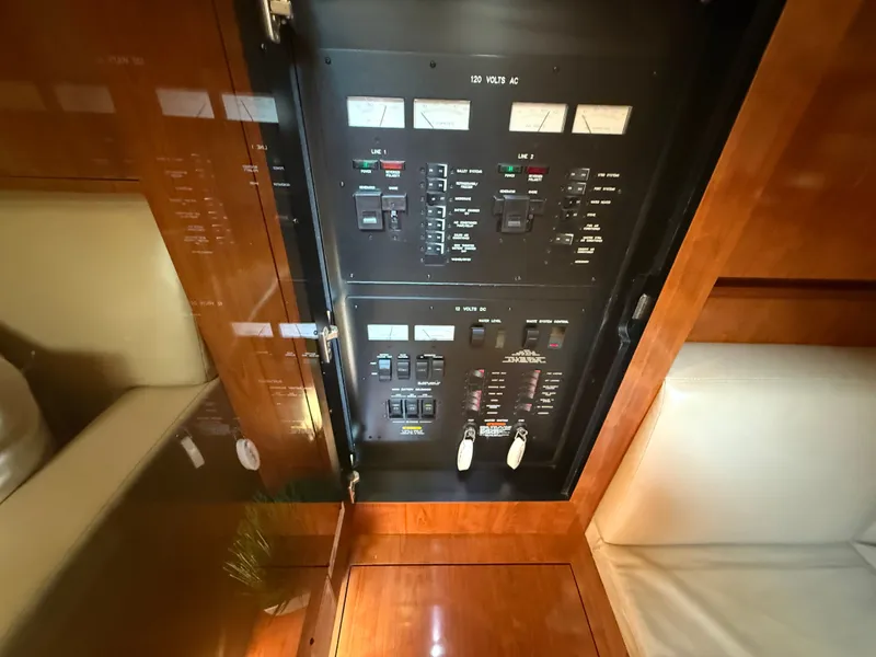 Slide: The Image of Electrical panel inside 2004 Sea Ray 390 Sundancer yacht, featuring switches and meters. - 11