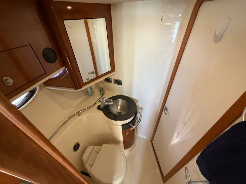 Slide: The Image of 2004 Sea Ray 390 Sundancer bathroom with sink, toilet, and mirror. - 13