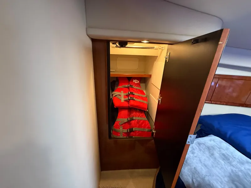 Slide: The Image of Storage cabinet with life jackets inside a 2004 Sea Ray 390 Sundancer yacht. - 16