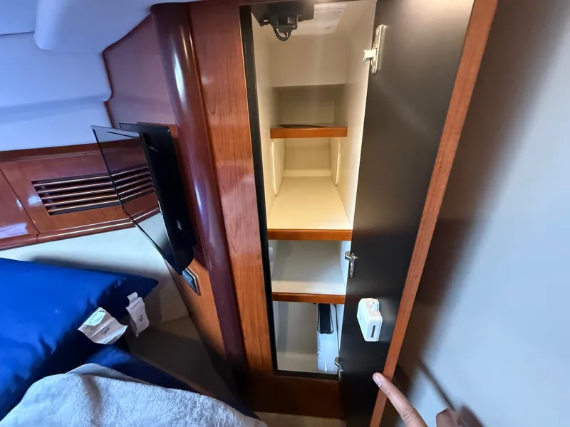 Slide: The Image of Interior of 2004 Sea Ray 390 Sundancer with open wooden cabinet and bed. - 17