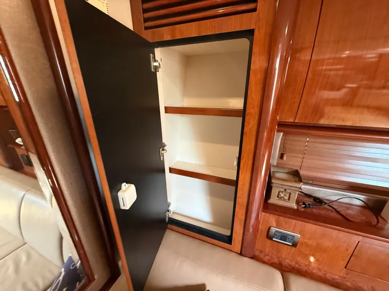 Slide: The Image of 2004 Sea Ray 390 Sundancer interior cabinet with open door and wooden shelves. - 18