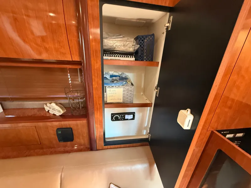 Slide: The Image of 2004 Sea Ray 390 Sundancer interior cabinet with wooden finish and storage shelves. - 20