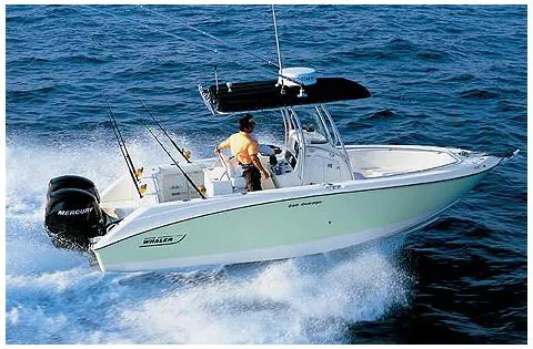 Slide: The Image of 2006 Boston Whaler 240 Outrage boat on trailer, named "Stella Bella," parked outside a building. - 1