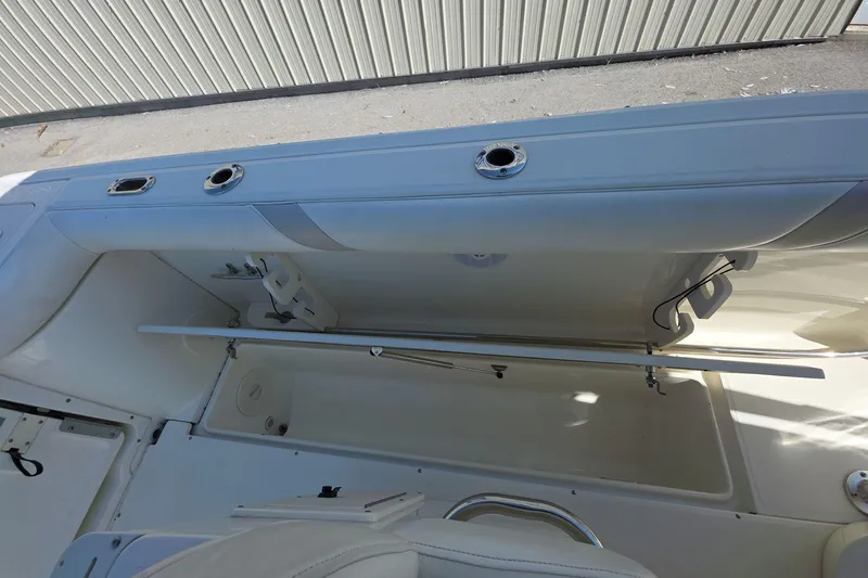 Slide: The Image of Boston Whaler 240 Outrage 2006 boat interior storage compartment with rod holders. - 10